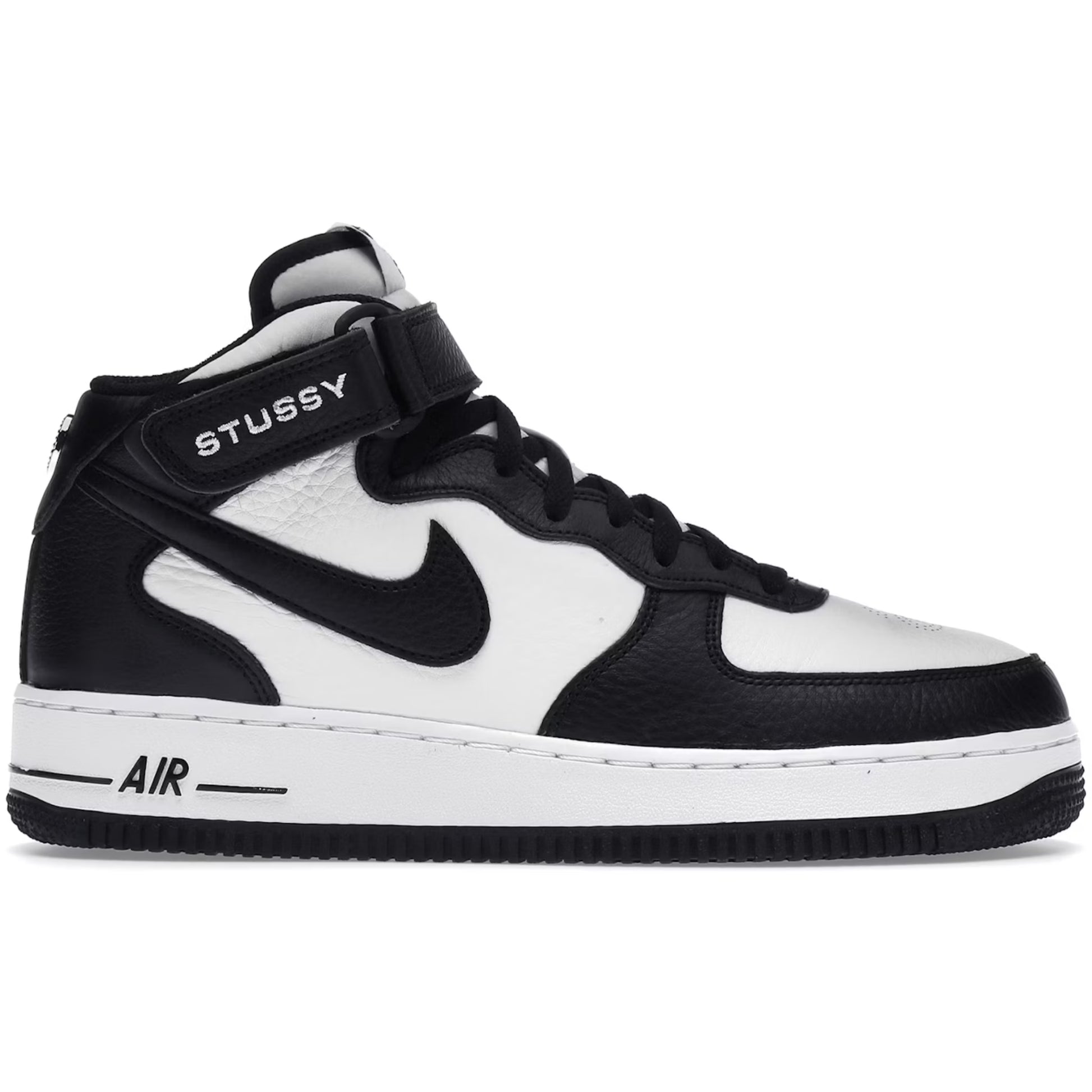 Black and white sneaker with Stussy branding on a white background