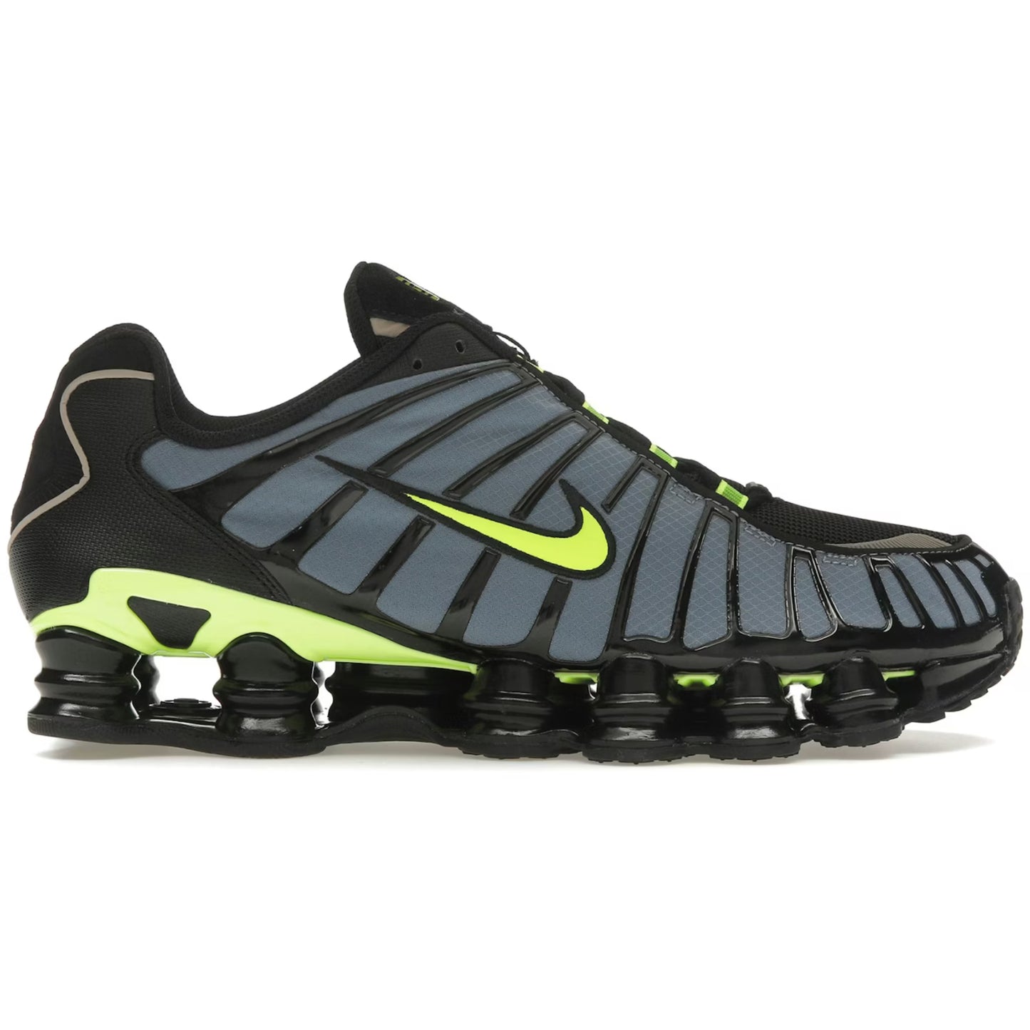 Black and gray sneaker with green accents on a white background