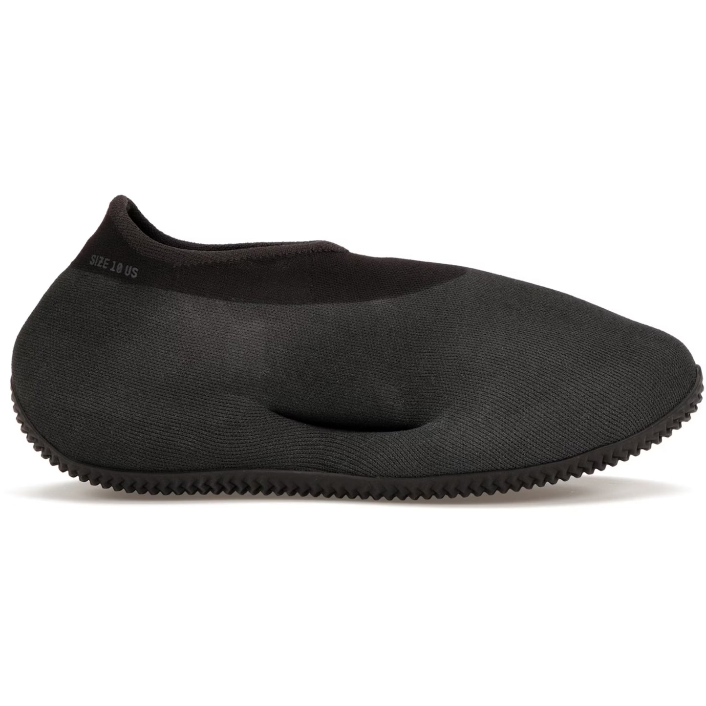 Black slip-on shoe with textured sole on a white background
